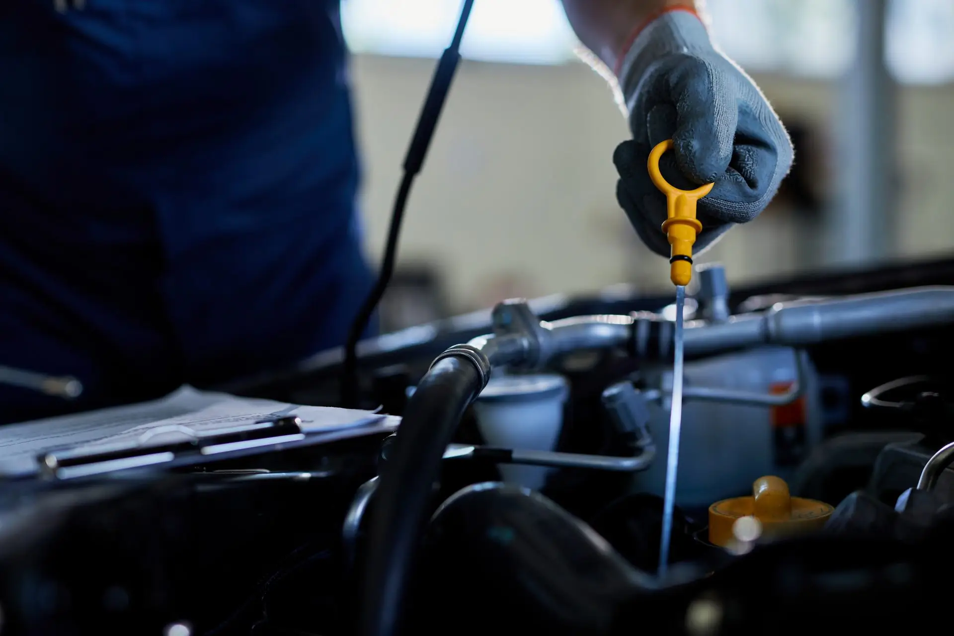 primer plano reparador automoviles que revisa aceite automovil taller